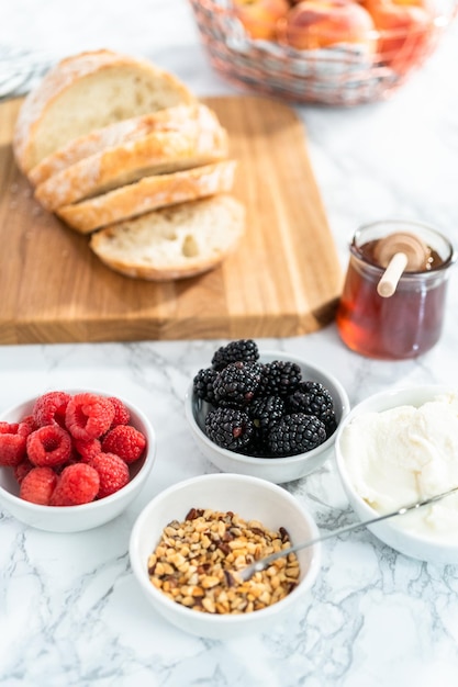 Ingrediënten voor het bereiden van perzik ricotta toast op een marmeren aanrecht.