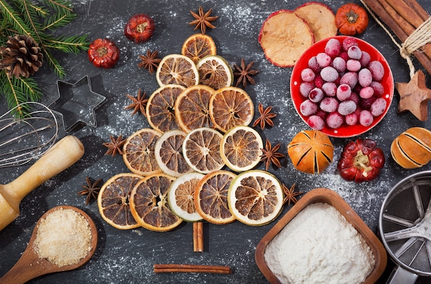 Ingrediënten voor het koken van een kerstbakdennenboom gemaakt van gedroogd fruit op een donkere tafel