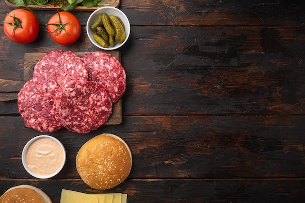 Ingrediënten voor het koken van hamburgers. Rundergehaktpasteitjes, broodjes, tomaten, kruiden en specerijen