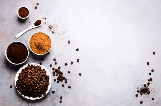 Ingrediënten voor het maken van cafeïnedrank - bruine kokosnotensuiker, koffiebonen, gemalen en oploskoffie op licht beton, kopie ruimte, bovenaanzicht.