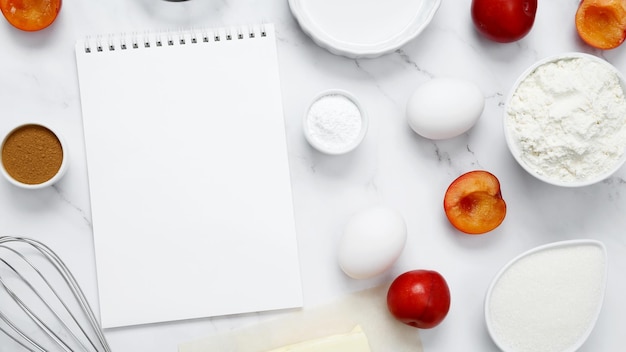 Ingrediënten voor het maken van klassieke taart met pruimen op witte achtergrond