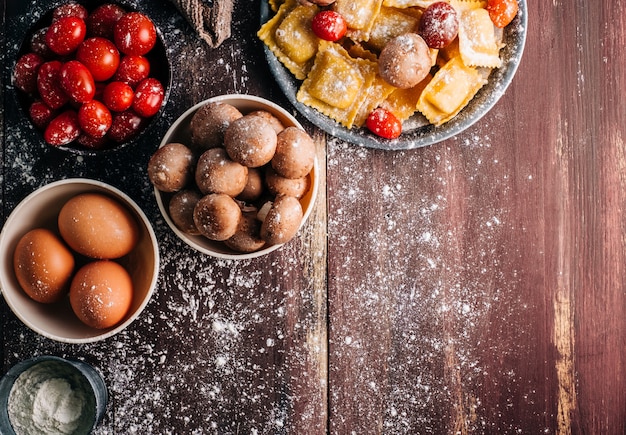 Ingrediënten voor het maken van zelfgemaakte ravioli met champignonsaus op een oude houten tafel. Italiaans veganistisch eten. Copyspace