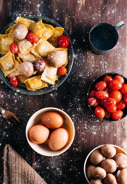 Ingrediënten voor het maken van zelfgemaakte ravioli met champignonsaus op een oude houten tafel. Italiaans veganistisch eten. Copyspace