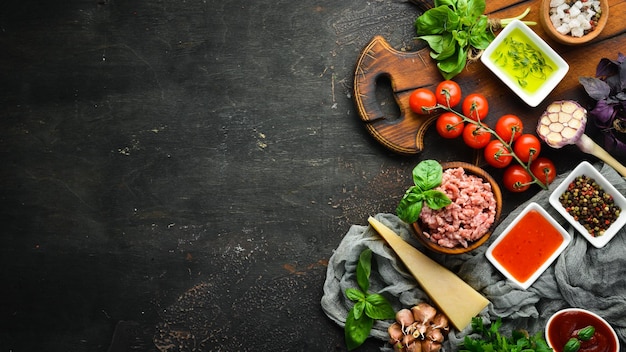 Ingrediënten voor kooksaus Bolognese Op een zwarte achtergrond Bovenaanzicht Vrije ruimte voor uw tekst