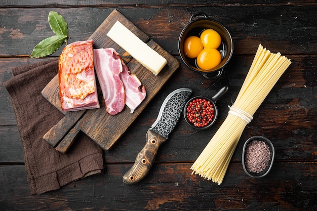 Ingrediënten voor Pasta Carbonara. Traditioneel Italiaans eten ingesteld, op oude donkere houten tafel, bovenaanzicht plat lag