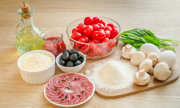 Ingrediënten voor pizza op een houten bord