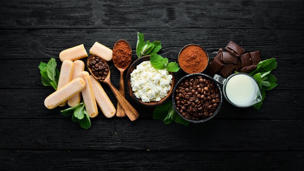 Ingrediënten voor Tiramisu Dessert Bovenaanzicht Op een zwarte houten tafel Vrije ruimte voor uw tekst