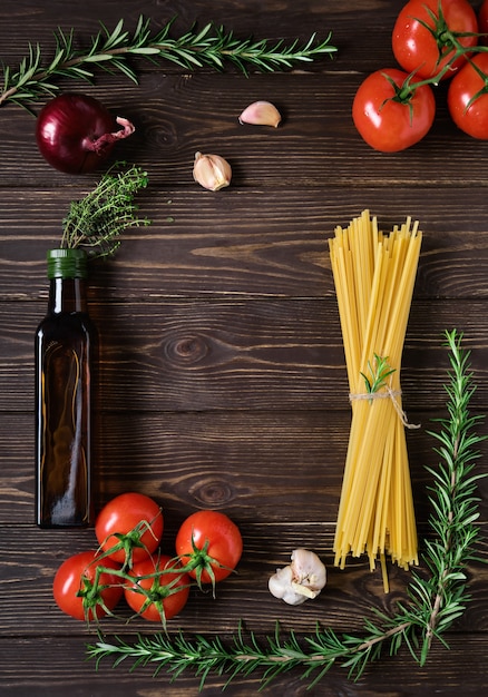 Ingrediënten voor vegetarisch spaghettirecept. Volkoren pasta op een rustieke donkere houten tafel