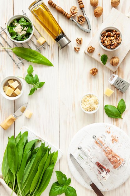 Ingrediënten voor Wild Garlic Pesto koken heerlijke hartige saus voor Italiaanse pasta Ramson kruiden kaas walnoten basilicum olijfolie Bovenaanzicht op witte achtergrond