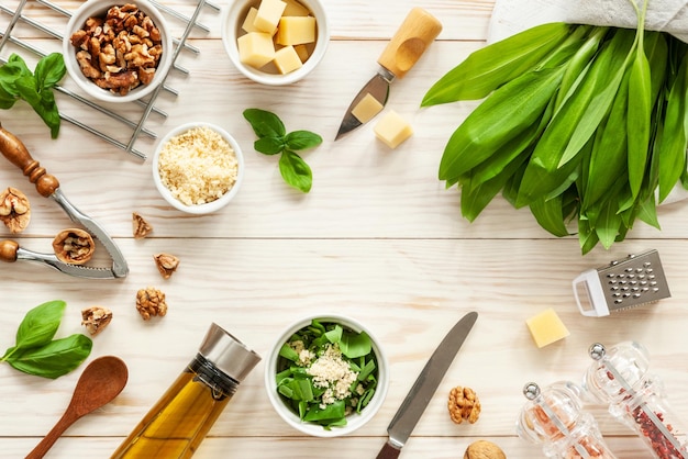 Ingrediënten voor Wild Garlic Pesto koken heerlijke hartige saus voor Italiaanse pasta Ramson kruiden kaas walnoten basilicum olijfolie Bovenaanzicht op witte achtergrond