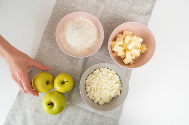 アップルパイの材料。小麦粉、バター、カッテージチーズ、リンゴのプレート。上面図。
