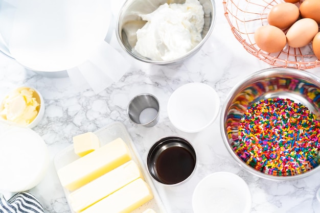 Ingredients to bake funfetti cake with colorful sprinkles.