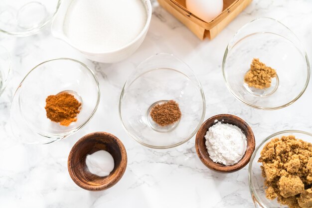 Ingredients to bake pumpkin spice cupcake on a marble countertop.