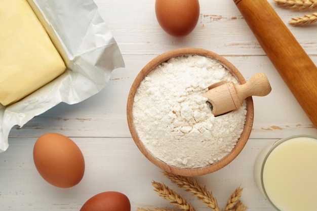 Ingredients for baking or cooking egg flour rolling pin butter milk on a white wooden background Cookie pie or cake recipe