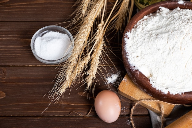 Ingredients for baking on a wooden table. Flour, eggs, wheat, salt. Top view.