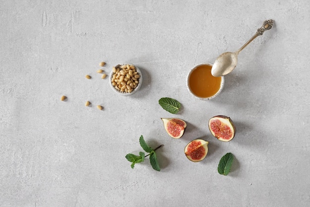 Foto ingredienti per la bruschetta con fichi maturi pinoli e miele su sfondo chiaro vista dall'alto