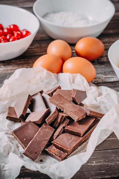 Ingredienti per torta di cioccolato brauni su fondo di legno nero