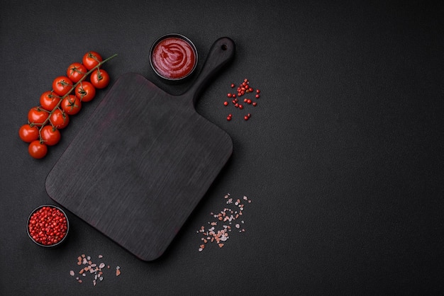 Ingredients for cooking cherry tomatoes salt spices and an empty cutting board