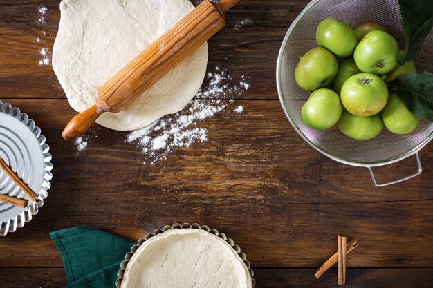 Ingredients for cooking homemade apple pie on old rustic wooden table top view