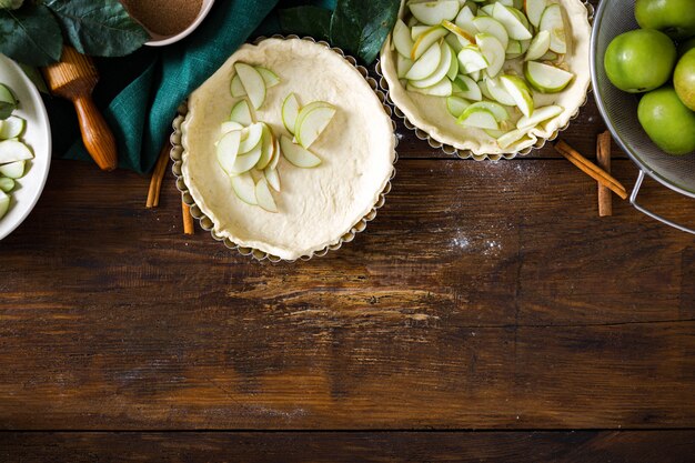 Ingredients for cooking homemade apple pie on wooden table with copyspace top view