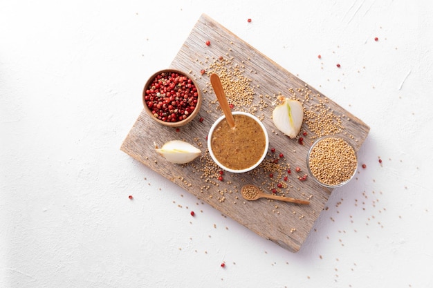Ingredients for cooking mustard on a wooden board on a white background top view