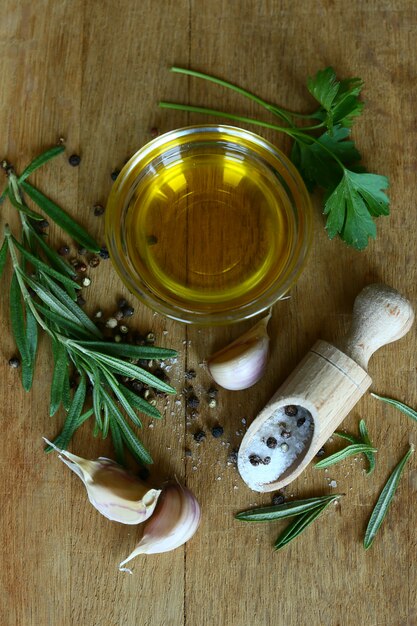 Ingredienti per cucinare. olio d'oliva con erbe aromatiche piccanti, aglio e sale marino. mangiare cibo. olio d'oliva, aglio, pepe, sale e rosmarino