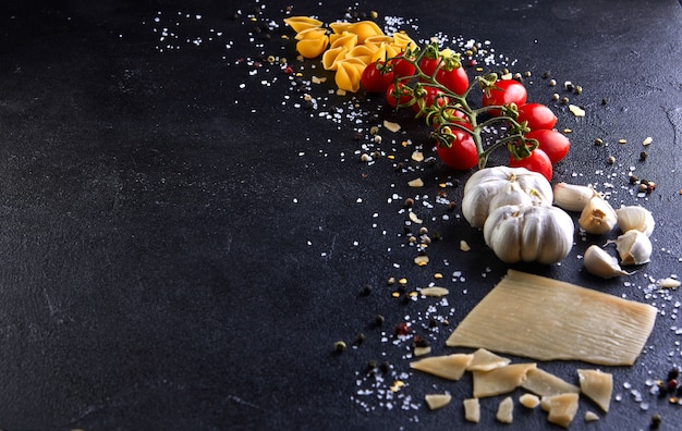 Ingredients for cooking pasta on black.