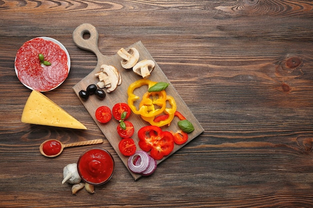 Foto ingredienti per cucinare la pizza sul tavolo in legno vista dall'alto