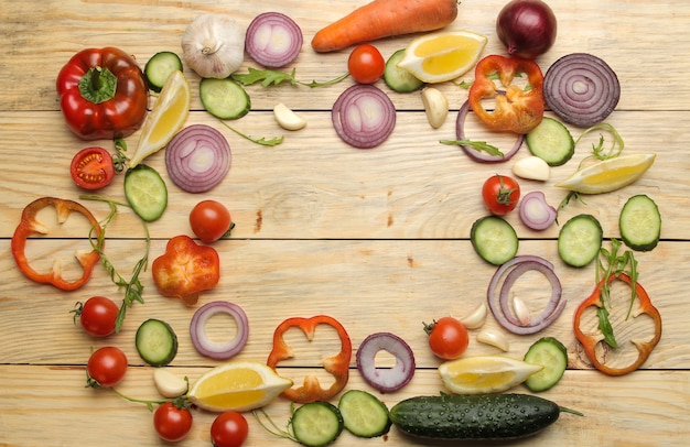 Ingredients for cooking salad. frame of Various vegetables and spices carrot, tomato, onion, cucumber, pepper and arugula on a natural wooden table. top view.