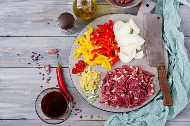 Ingredients for cooking stir-fry from chicken hearts, paprika and onions. Chinese cuisine. Top view