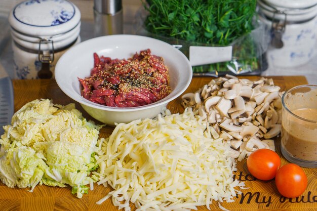 Ingredients for cooking stirfry or quesadilla tacos from meat mushrooms salad cheese and tomatos