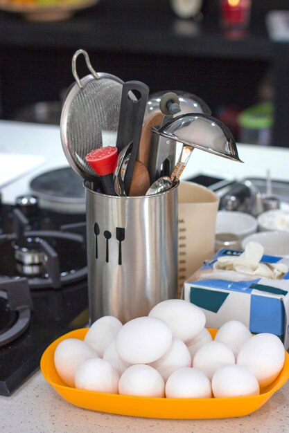 Ingredients and cooking utensils on a table in a metal cup.