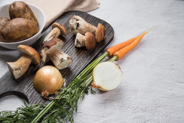 Ingredients for cooking various dishes from forest porcini mushrooms on a light background