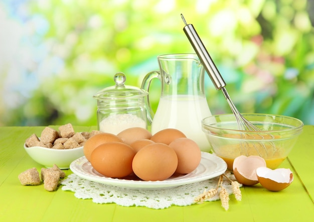 Ingredients for dough on wooden table on natural background