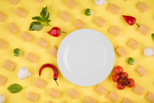 Фото Ингредиенты для приготовления пищи расположены на желтом фоне. концепция итальянской кухни