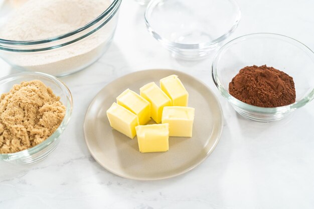 Ingredients in glass mixing bowls to bake chocolate graham crackers