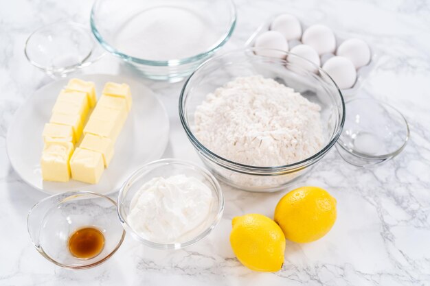 Ingredients in glass mixing bowls to prepare lemon bundt cake.