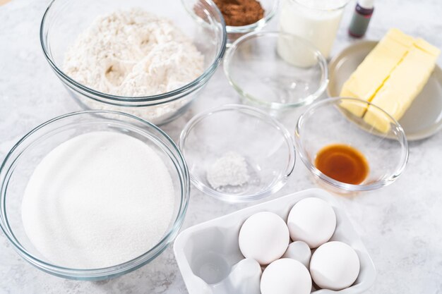 Ingredients in glass mixing bowls to prepare red velvet bundt cake.