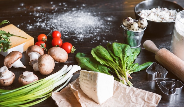 Ingredienti per i ravioli verdi a forma di cuore di spinaci con ricotta. preparato dalla padrona di casa per una cena festiva il giorno di san valentino