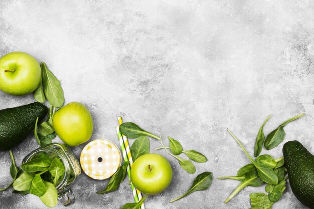 Ingredients for green smoothie - apples, spinach, celery, avocado on a light background. Top view, copy space. Food background.