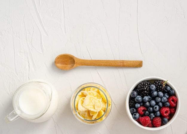 Ingredients for a healthy breakfast - cornflakes, berries, milk