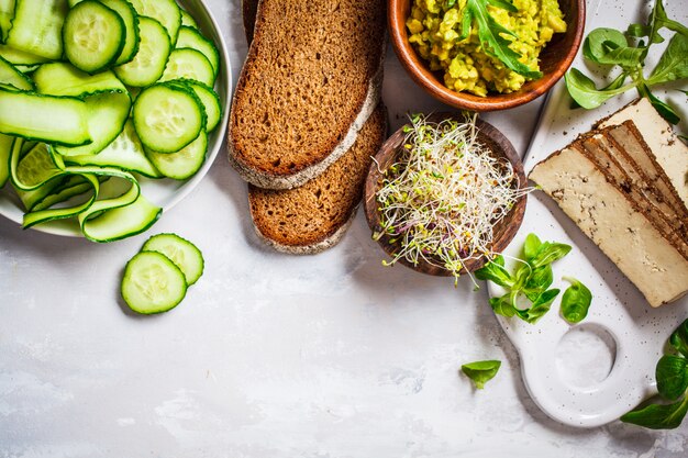 Ingredients for healthy vegetarian sandwich with tofu, vegetables and guacamole