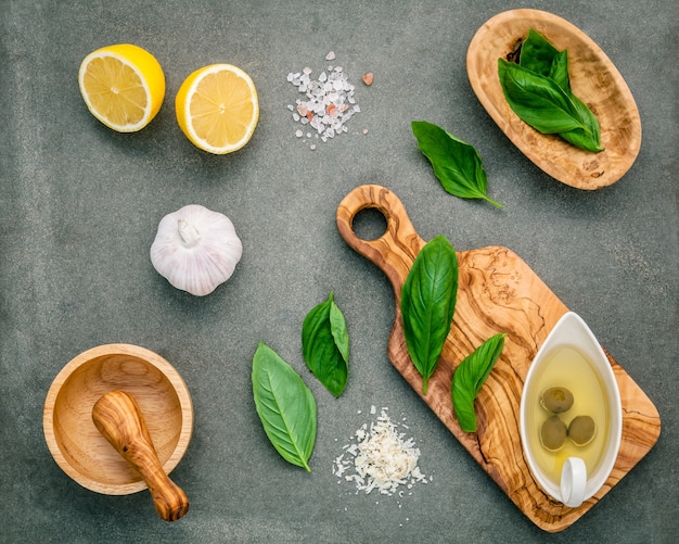 The ingredients for homemade pesto sauce on concrete background.