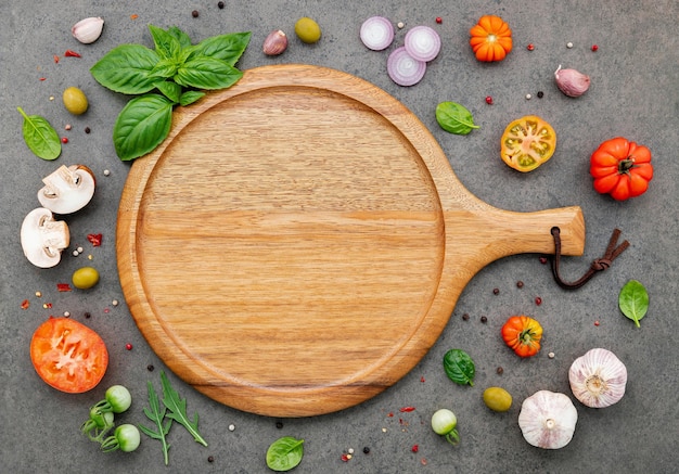 The ingredients for homemade pizza set up on dark stone background