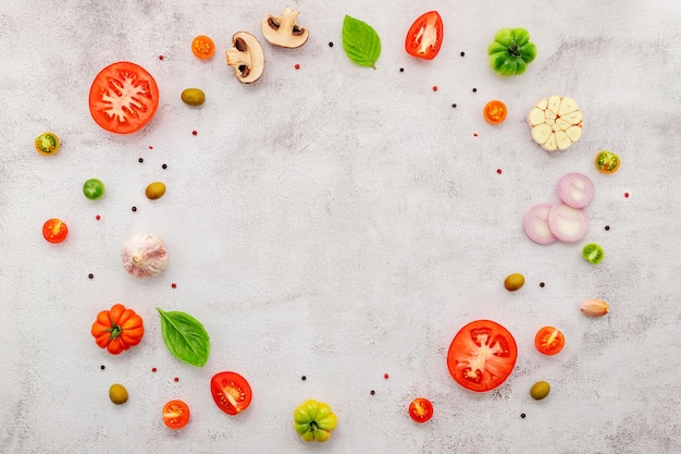 The ingredients for homemade pizza set up on white concrete background