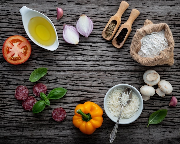 Photo the ingredients for homemade pizza on shabby wooden background