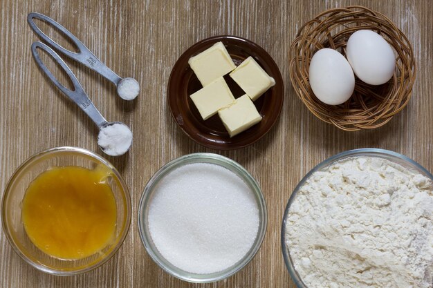 Ingredients for honey cake honey butter sugar eggs flour soda salt on wooden background