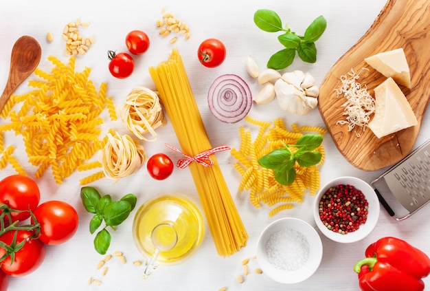 Ingredients for italian cousine flat lay, pasta spaghetti penne fusilli tomato oil vegetables