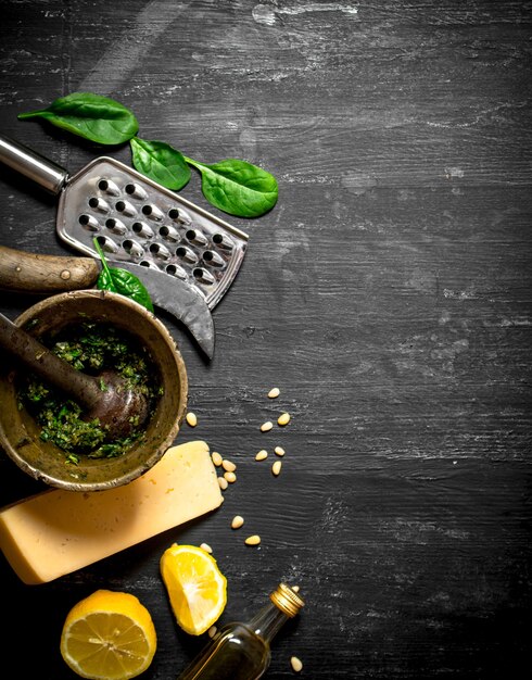 Ingredients for Italian pesto on the black wooden table.