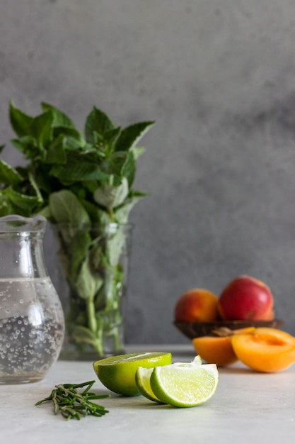 Ingredients for lemonade (apricot, mint, rosemary and lime). 